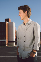 side profile of a young man standing in a parking lot 