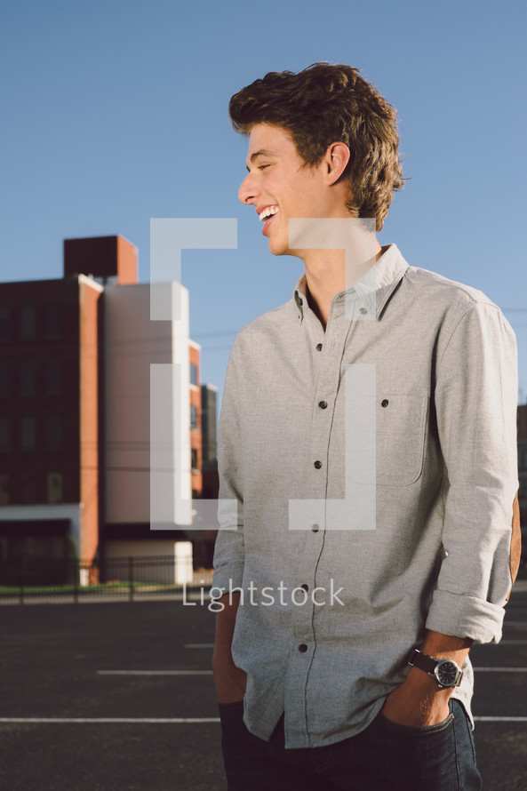 side profile of a young man standing in a parking lot 