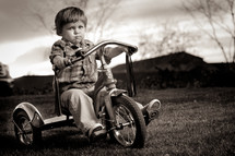 toddler boy riding a tricycle