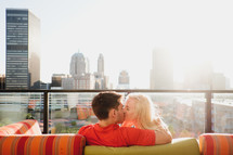 a couple kissing on a balcony 