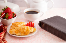croissants and strawberries with a Bible 