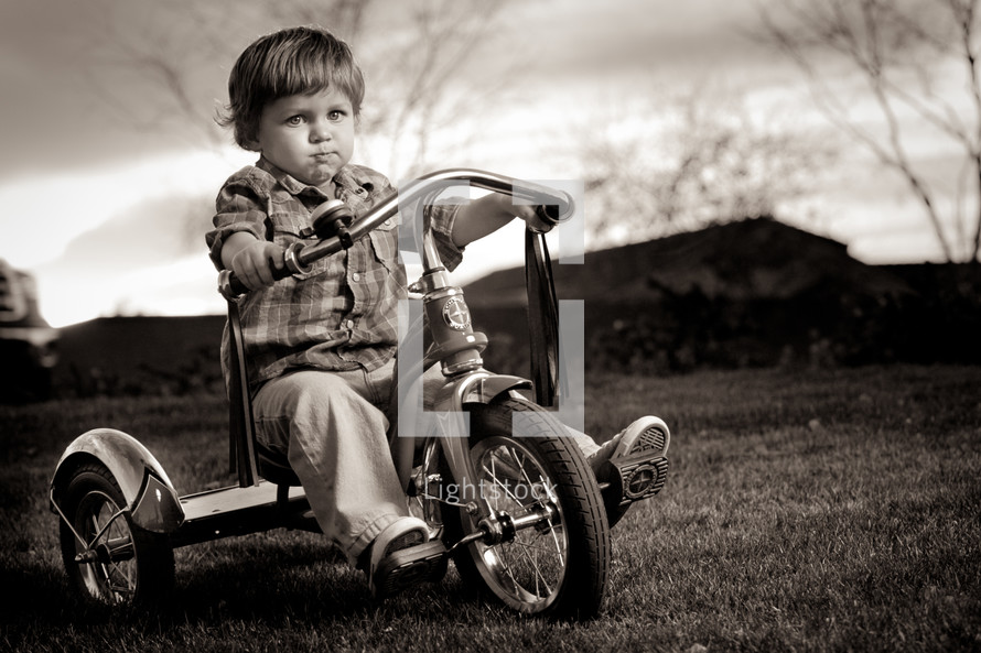 toddler boy riding a tricycle