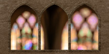 intentionally blurred stained glass windows viewed through stone arches