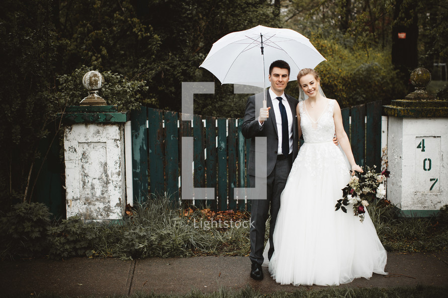 bride and groom with an umbrella 