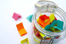 folded papers in a jar 