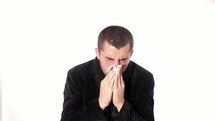 man sneezing into a tissue 