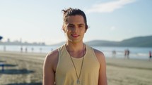 White man looking at camera. Closeup positive guy smiling and laughing at camera. Portrait of male model posing on camera at the beach. Cheerful man face with positive emotion outdoors
