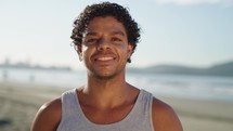 Close up portrait of attractive mixed race man smiling at the beach on a sunny day
