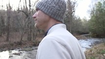 a man standing by a creek 