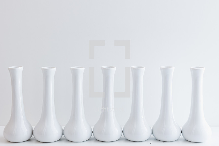 Row of empty white vases on a white background with copy space