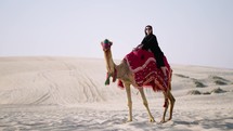 Tourist woman riding camel at the desert
