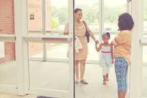 a greeter welcoming a mother and daughter 