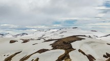 Clouds moving over snowy rainbow mountains in Iceland in Landmannalaugar. Time lapse pan
