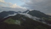 Flight over misty forest in mountains
