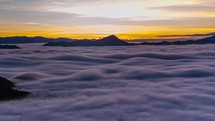 Waves of foggy clouds at sunrise in misty mountains nature Time lapse
