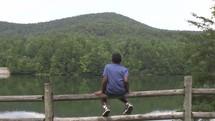 a child looking out at mountains and a lake 