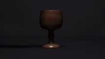 pouring wine into a wooden chalice 
