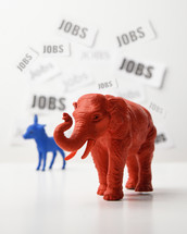 A blue donkey and a red elephant are againts a white wall that has job text in the background for a 2020 political issue of employment rate and the economy.