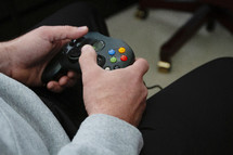 man's hands holding a video game controller 