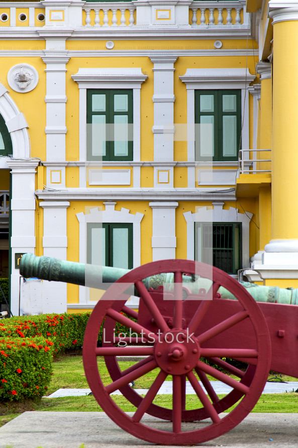 old cannon, and yellow building, in Bangkok
