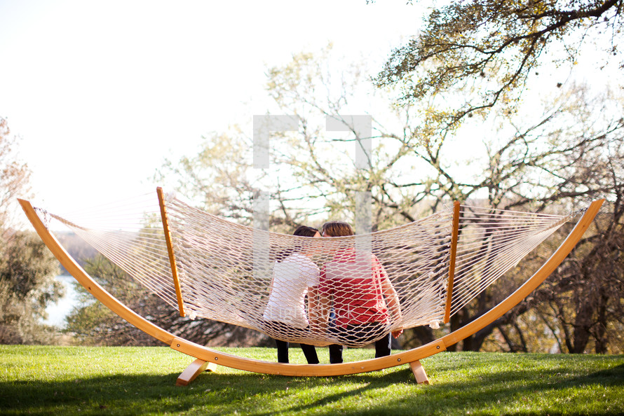 man and woman kissing on a hammock