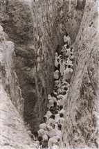 crowd of people in a narrow crevice heading towards a celebration 