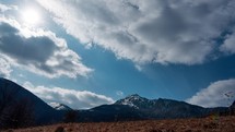Hilly rural alpine landscape, early spring, last remnants of snow on high mountain, timelapse
