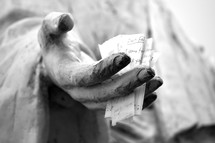 A note to "Our Father" in the hand of a statue of Jesus.