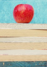 A stack of books with an apple on top.