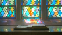 old chapel bible on an altar stained glass dolly-zoom wide angle 