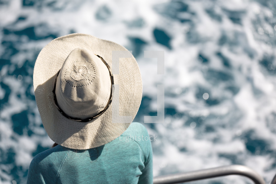 a woman on a ship in a straw hat 