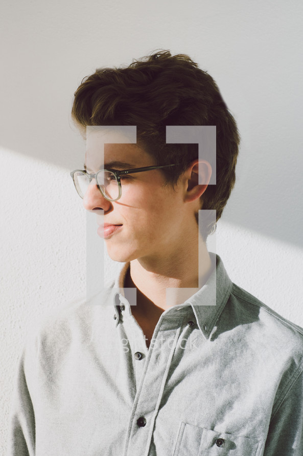 side profile of a young man in glasses 