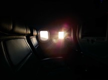 sunlight through a plane window and empty seats 