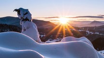 Time lapse of winter sunrise in snowy mountains.

