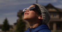 Young boy watches Solar Eclipse with special glasses