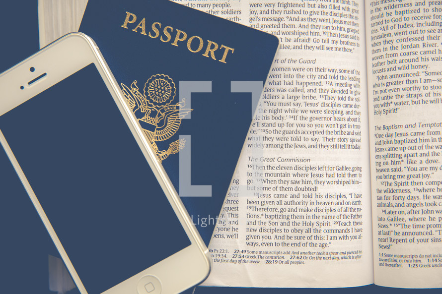 iPhone and passport on the pages of a Bible 