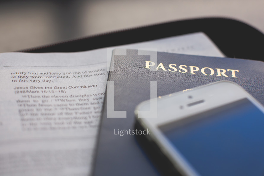 an iPhone, passport, and open Bible 