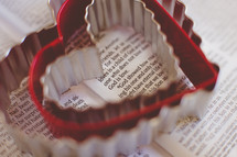 Heart shaped cookie cutters on the pages of a Bible 