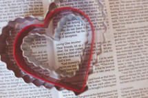 Heart shaped cookie cutters on the pages of a Bible. 