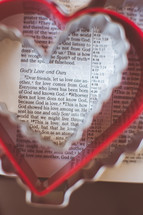 heart shaped cookie cutters on the pages of a Bible. 