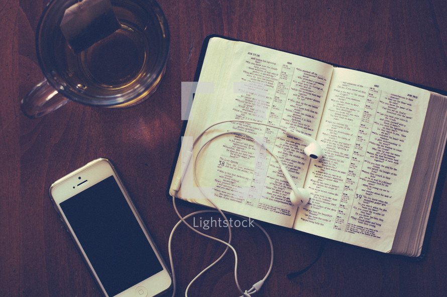iphone, ear buds, tea, and a Bible 