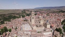Segovia Cathedral, towering above cityscape, vast countryside backdrop	
