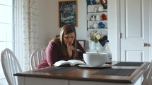 a woman reading a Bible at home 