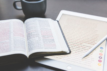 An open Bible, electronic tablet, and a cup of coffee.