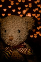 teddy bear in front of heart lights