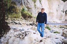 a man walking over a rocky landscape 