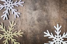 snowflake ornaments on a wood background 