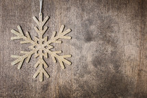 snowflake ornament on a wood background 