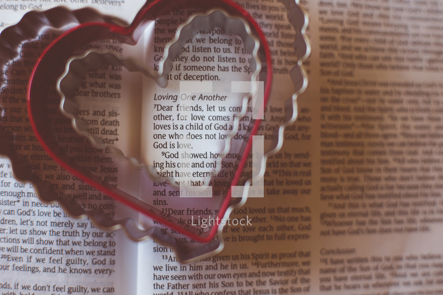 Heart shaped cookie cutters on the pages of a Bible. 