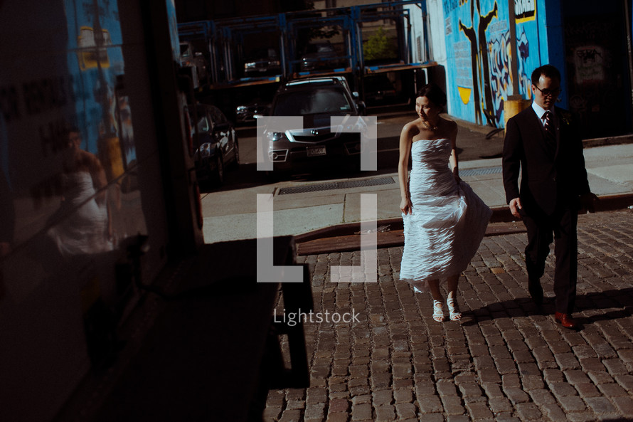 bride and groom on a cobble stone street 